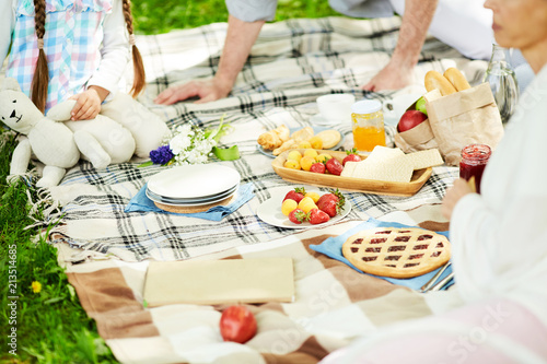 Fresh strawberries and apricots and other food on tablecloth served for family picnic