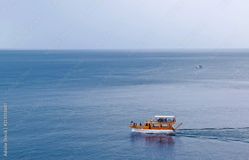 A pleasure yacht takes people on a tour of the Mediterranean. A ship on the background of the sea and sky. A pleasure yacht takes people on a tour of the Mediterranean. A ship on the background of the sea and sky.