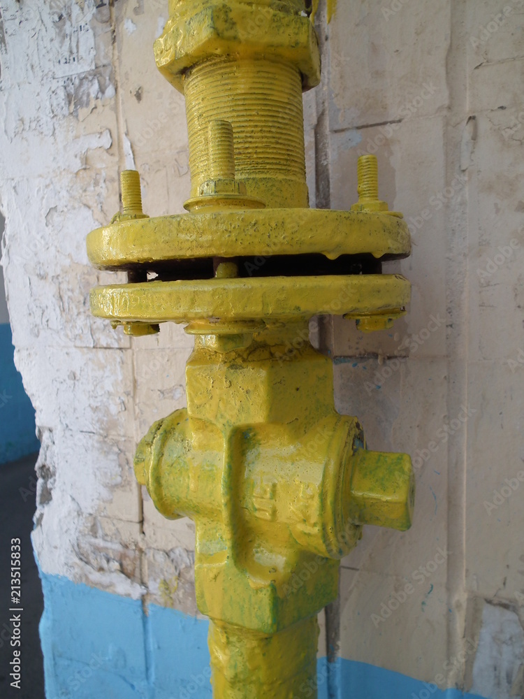 Old yellow gas valve on the wall Old yellow gas valve on the wall