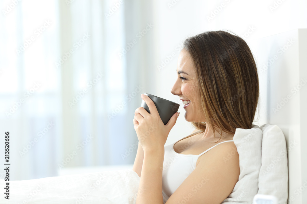 Girl drinking coffee at breakfast in the morning on the bed Girl drinking coffee at breakfast in the morning on the bed
