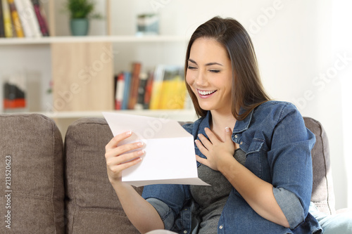 Candid woman reading hopeful news in a letter