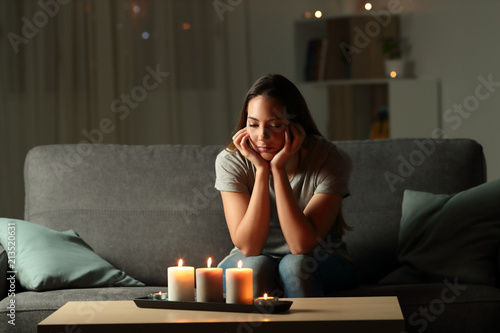 Distracted woman looking at candles light during blackout