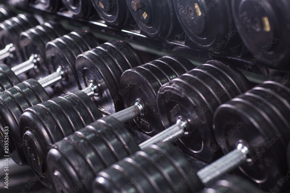 Black dumbbell set in sport fitness center. Weight Training Equipment concept. Black dumbbell set in sport fitness center. Weight Training Equipment concept.
