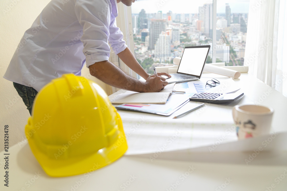 Architect man working with laptop and blueprints, Engineer inspection in workplace for architectural plan, Sketching a construction project , Selective focus, Business concept vintage color Architect man working with laptop and blueprints, Engineer inspection in workplace for architectural plan, Sketching a construction project , Selective focus, Business concept vintage color