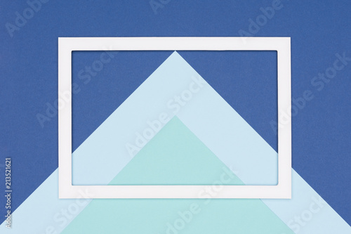 Abstract geometrical flat lay pastel blue and turquoise colored paper background. Minimalism, geometry and symmetry template with empty picture frame mock up.
