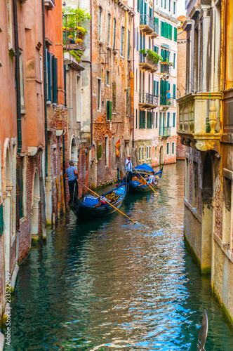 Gondoliers Calmly Propelling Along Canal in Venice, Italy © YukselSelvi