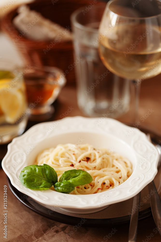 Lunch meal pasta with cream sauce, served with glass of white wine Lunch meal pasta with cream sauce, served with glass of white wine