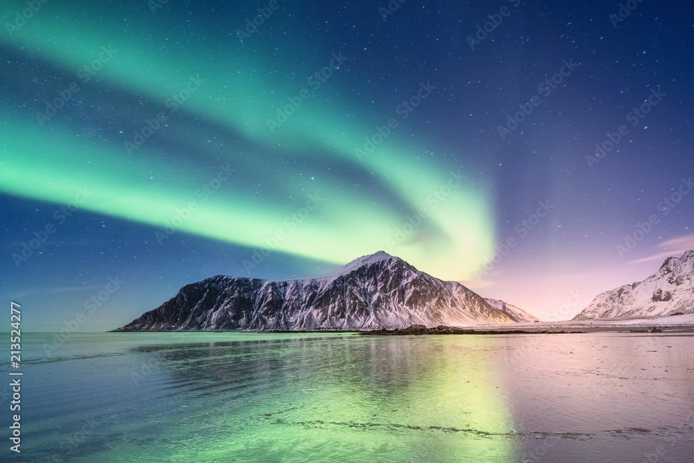 Northen light above mountains and ocean shore. Beautiful natural landscape in the Norway