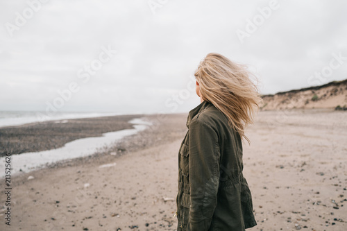 Blond woman on the beach - windy hair