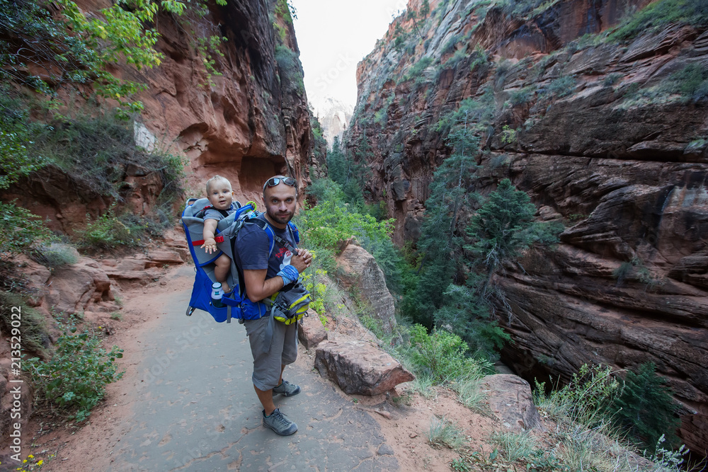 Obraz premium A man with his baby boy are trekking in Zion national park, Utah, USA