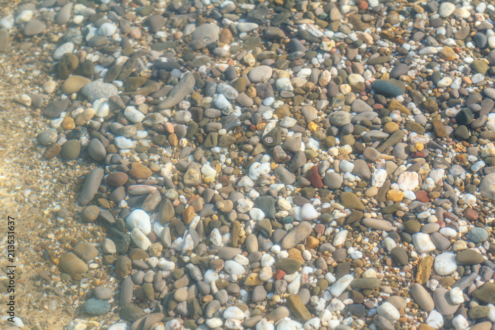the texture of the pebbles of the sea with wave and focus