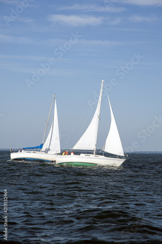 A Pair of Sailboats Next to One Aother Leaning at Full Sail in Maine