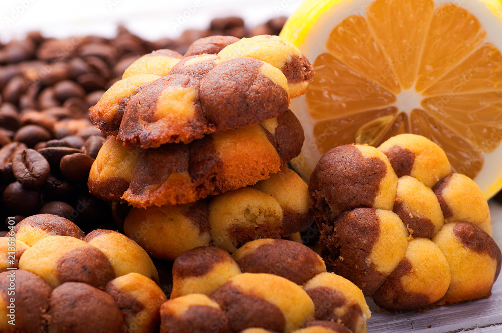 Unusual cute cookies with lemon and coffee close-up. Sweet pastries in the form of flowers. Dessert with citrus taste. Grains of coffee for decoration in the background. Unusual cute cookies with lemon and coffee close-up. Sweet pastries in the form of flowers. Dessert with citrus taste. Grains of coffee for decoration in the background.