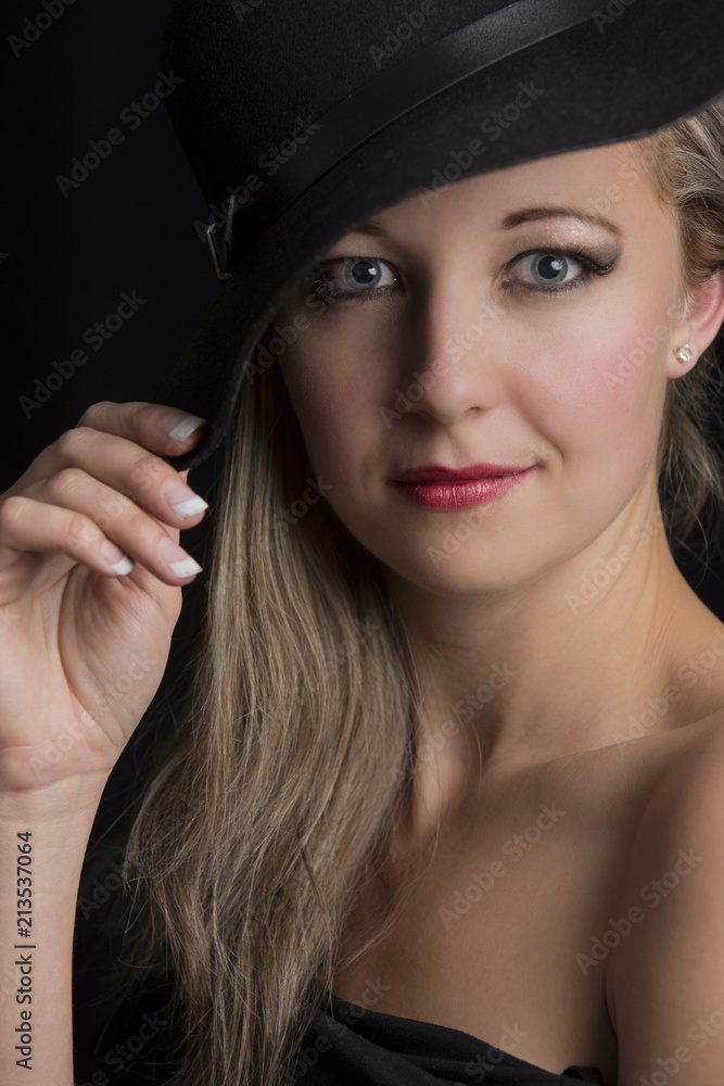 Portrait close-up of a beautiful blond woman with black hat