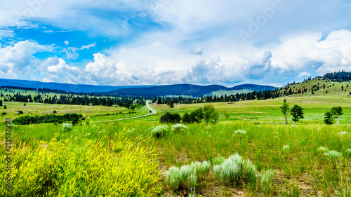 Highway 5A winding through the wide open Grass Lands of the Nicola Valley, between Merritt and Kamloops, British Columbia, Canada, under partly cloudy sky photo