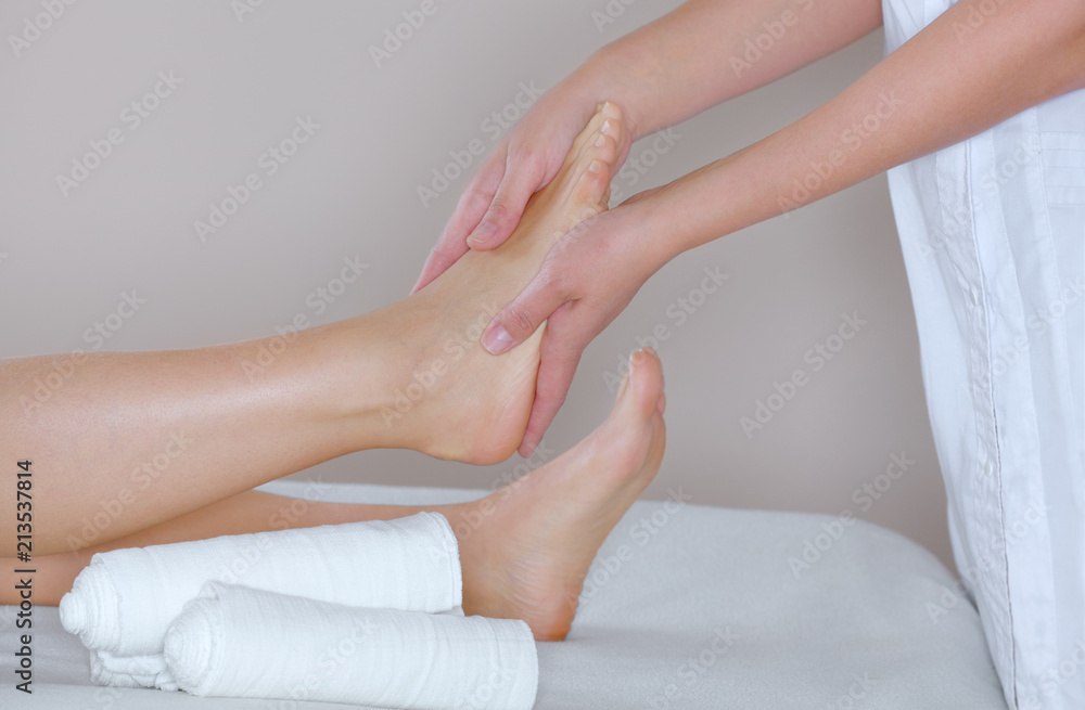 The cosmetologist wraps the leg of the customer. Anti-cellulite procedure-STYX wrap. The cosmetologist wraps the leg of the customer. Anti-cellulite procedure-STYX wrap.