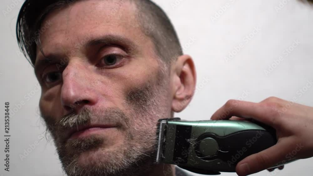 Hairdresser shaving beard of attractive man in barbershop Hairdresser shaving beard of attractive man in barbershop