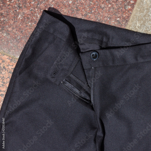 Black men's trousers lie on the old porch, dark pants made of natural cloth on a gray background, men's clothing on a natural background, blank for a designer, tailoring clothes for a store