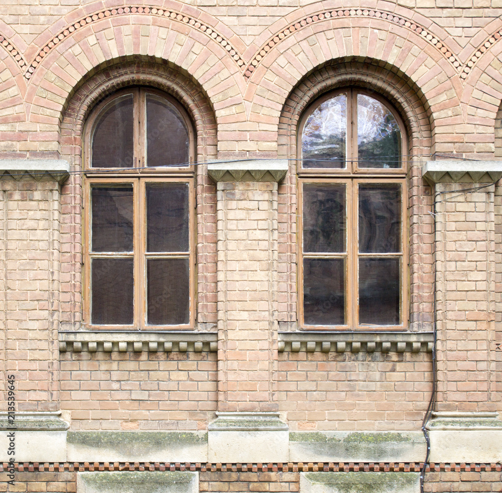 Photo of wooden window in a decorative brick wall