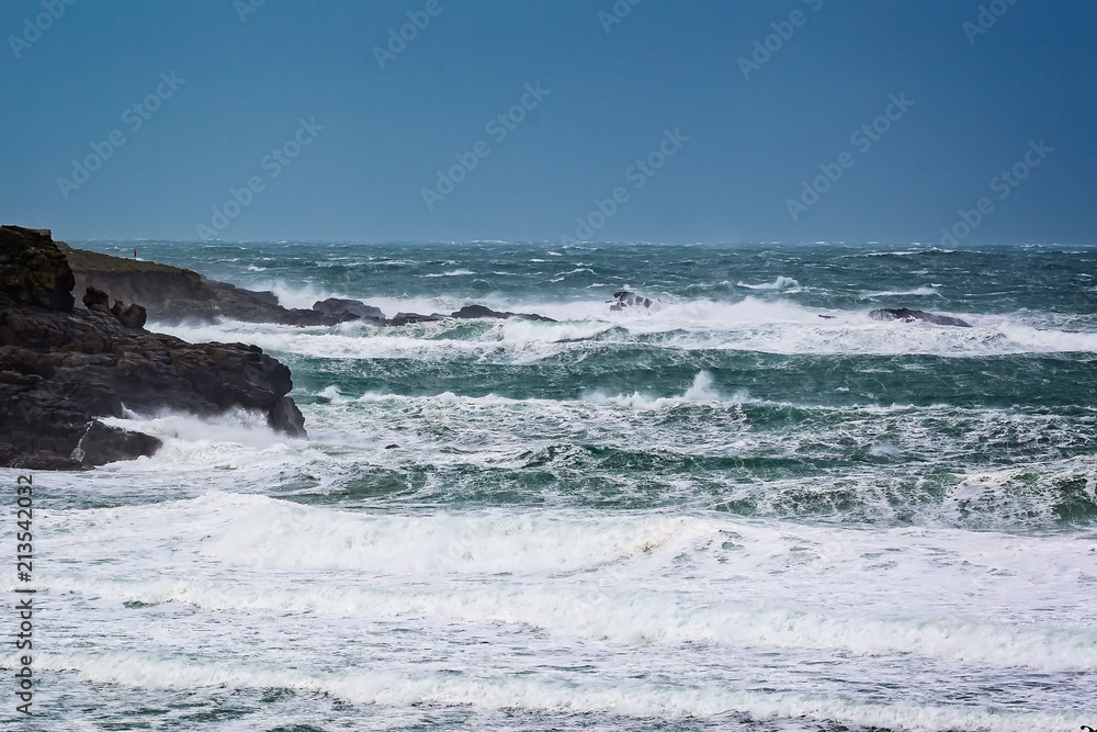 Dramatic stormy sea with large waves crashing onto rocks