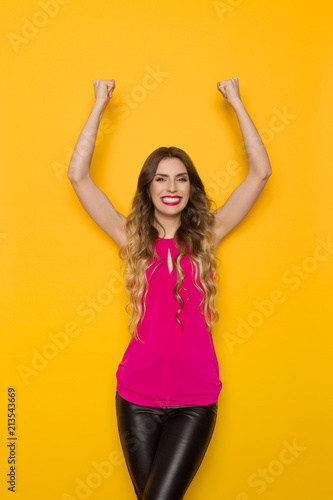 Happy Young Woman Is Cheering With Arms Raised