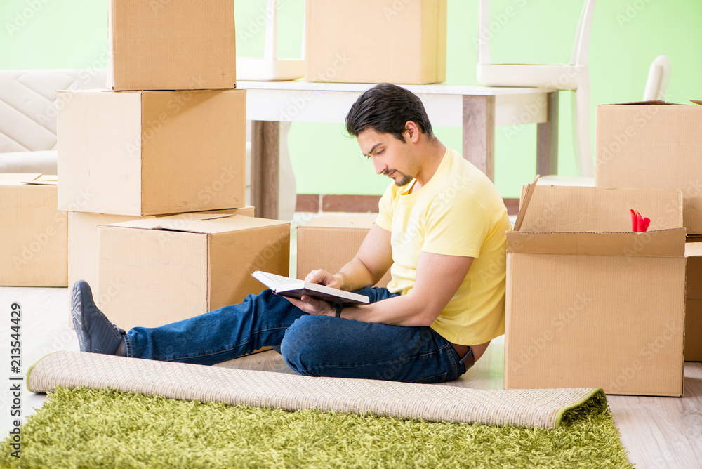 Young handsome man moving in to new house with boxes Young handsome man moving in to new house with boxes