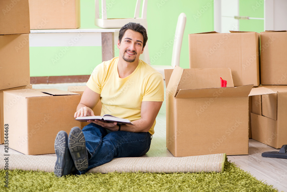Young handsome man moving in to new house with boxes Young handsome man moving in to new house with boxes