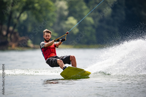 Wakeboarder surfing across a lake photo