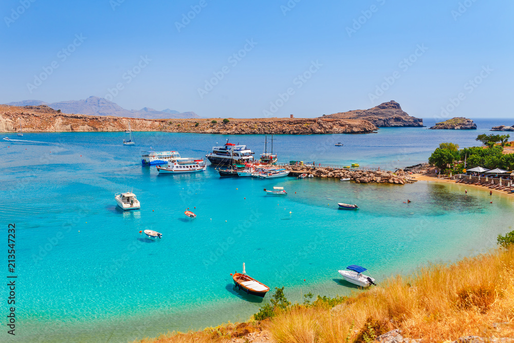 Fototapeta premium Sea skyview landscape photo Lindos bay and sea coast on Rhodes island, Dodecanese, Greece. Panorama with nice sand beach and clear blue water. Famous tourist destination in South Europe
