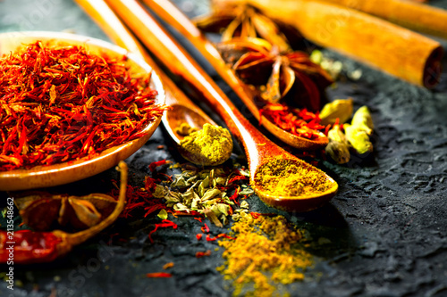 Fototapeta Naklejka Na Ścianę i Meble -  Spices. Various Indian spices on black stone table. Spice and herbs on slate background. Cooking ingredients
