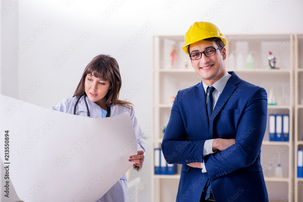 Doctor discussing new hospital plan with architect Doctor discussing new hospital plan with architect