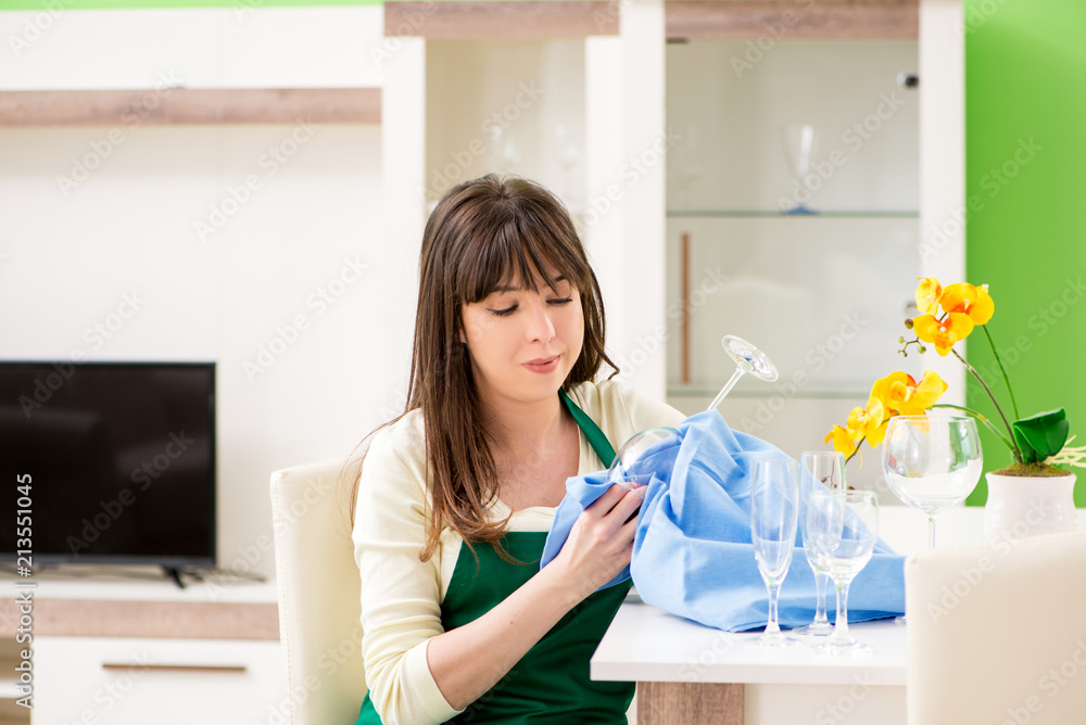 Young woman cleaning glasses at home Young woman cleaning glasses at home