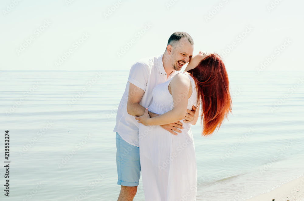 photo shoot of a pregnant couple on the beach. the girl has red hair photo shoot of a pregnant couple on the beach. the girl has red hair