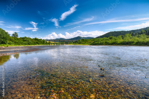 Mountain river stream of water in the rocks with majestic blue sky