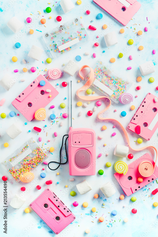 Cassette tapes and retro radio player in a pastel colour flat lay with candies, bonbons, marmalade and bubble gum. Sweet music concept with copy space. Vanilla palette Cassette tapes and retro radio player in a pastel colour flat lay with candies, bonbons, marmalade and bubble gum. Sweet music concept with copy space. Vanilla palette