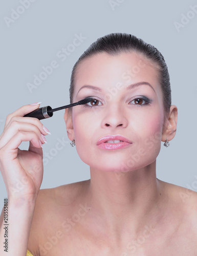 Close-up of a beautiful woman with a brush for mascara