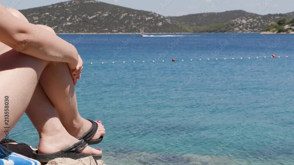 Woman in slippers watching boats 1