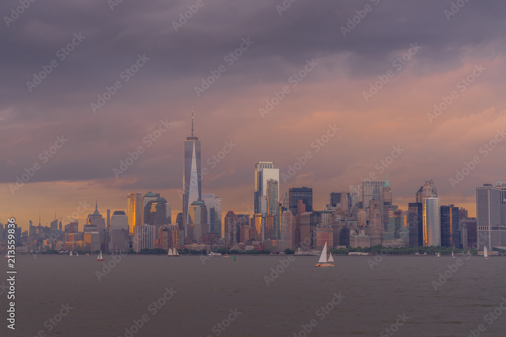 Panorama view of  NYC Lower Manhattan skyline with sailboats passing by in New York Harbor