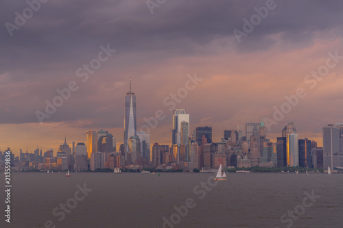Panorama view of NYC Lower Manhattan skyline with sailboats passing by in New York Harbor