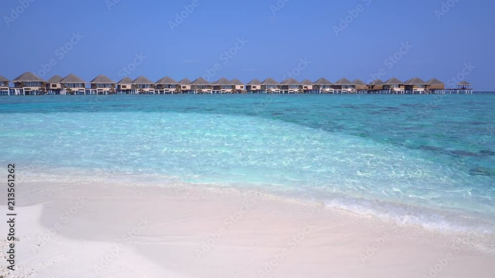 Tropical travel destination with pristine beach and water bungalows Tropical travel destination with pristine beach and water bungalows