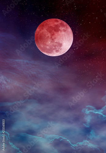 Red moon or blood moon with many stars and clouds on colorful sky.