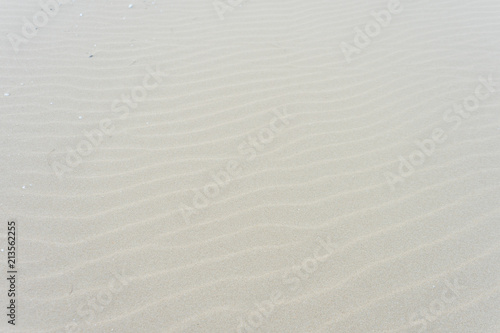 Fine beach sand with wave shape in the summer sun, Sand texture. Top view