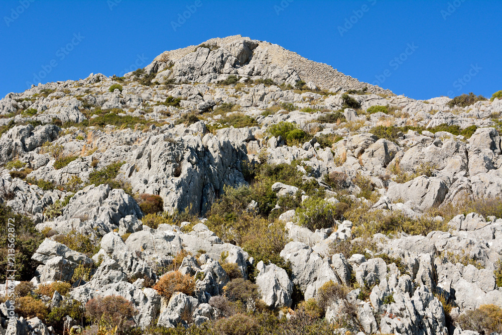 Rocky landscape topped by ruins of fortified castle located on the coastline between Sogut and Taslica near Marmaris resort town in Turkey.