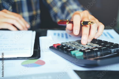 Businessman's hands with calculator at the office and Financial data analyzing counting