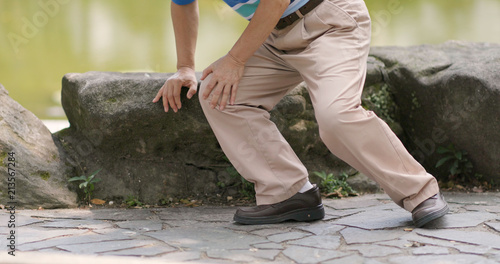 Old man suffer from pain on legs at outdoor