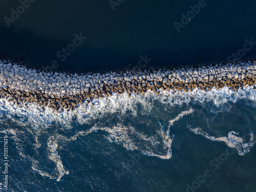  Aerial View of Ocean Waves Crashing on Jetty Rocks
