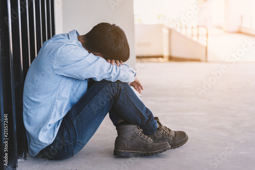Depressed man sitting on floor while against wall, Sad man, Cry, drama concept 