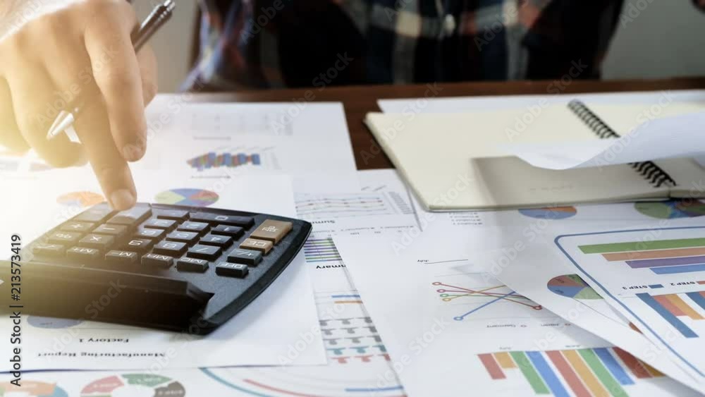 Hand of businessmen are written account calculated financial reporting, with charts, graphs. The concept of business finance and accounting and Business startup .. Hand of businessmen are written account calculated financial reporting, with charts, graphs. The concept of business finance and accounting and Business startup ..