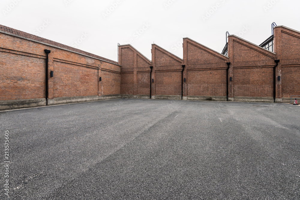 Fototapeta premium Brick wall and asphalt parking space