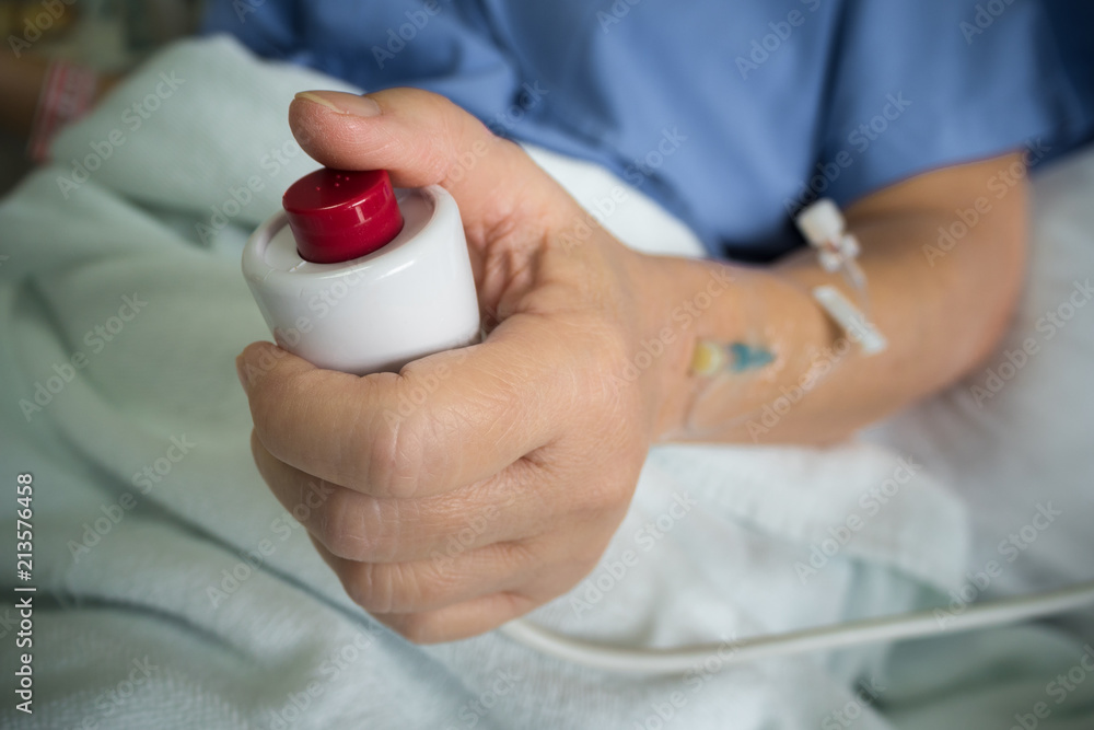 Patient hand pressing emergency nurse call button